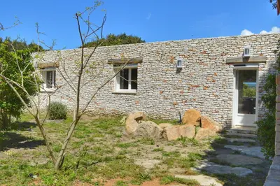 a stone house with a door and some rocks at Villa Serena - 10mn de la plage in Bonifacio