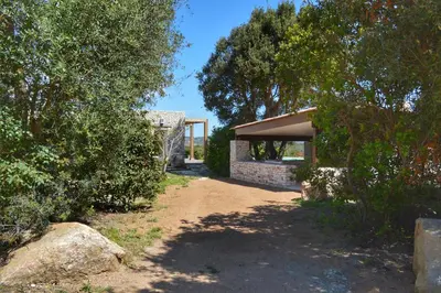 a house with a garage and trees and a dirt road at Villa Serena - 10mn de la plage in Bonifacio