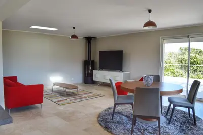 a living room with a table and chairs and a tv at Villa Serena - 10mn de la plage in Bonifacio