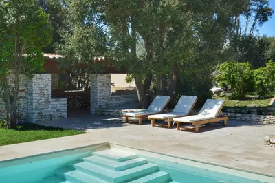 a group of lounge chairs next to a swimming pool at Villa Serena - 10mn de la plage in Bonifacio