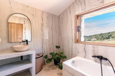 a bathroom with a sink and a tub and a window at A Casetta Rossa Bergerie a 15 min du centre ville d Ajaccio et 15 min des plages de Porticcio in Ocana