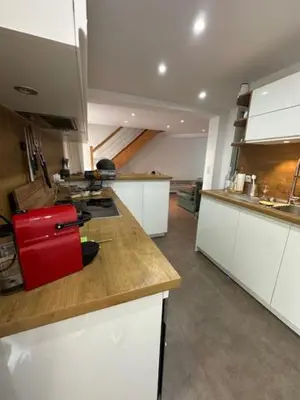 a kitchen with white cabinets and a red suitcase on a counter at Pietrosella Canelli Sea View in Pietrosella