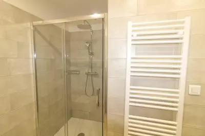 a shower with a glass door in a bathroom at Bel appartement 1 chambre pieds dans l'eau in Casaglione