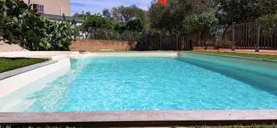 a swimming pool with blue water in a yard at 46m with terrace - residence with pool in Porto-Vecchio