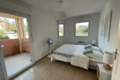 a bedroom with a bed and a door to a balcony at 46m with terrace - residence with pool in Porto-Vecchio