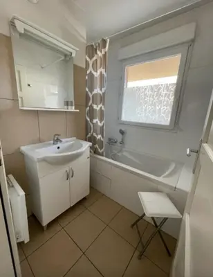 a bathroom with a sink and a tub and a window at 46m with terrace - residence with pool in Porto-Vecchio