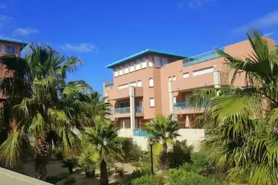 a building with palm trees in front of it at 46m with terrace - residence with pool in Porto-Vecchio