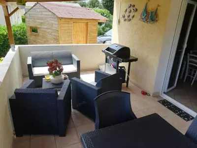 a patio with a table and chairs and a grill at Villa sur Travo , Solenzara in Vaccili