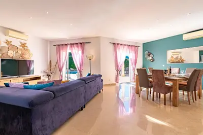 a living room with a large blue couch and a table at Villa Maria Magdalena - Avec piscine in Sari Solenzara