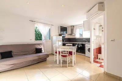 a living room with a bed and a table and a kitchen at Villa Maria Magdalena - Avec piscine in Sari Solenzara