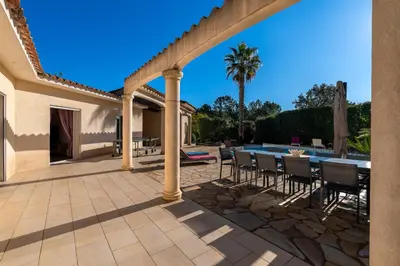 a patio with a table and chairs and a swimming pool at Villa Maria Magdalena - Avec piscine in Sari Solenzara
