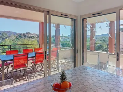 a dining room with a table and chairs on a balcony at Apartment Agnaredda by Interhome in Porto-Vecchio