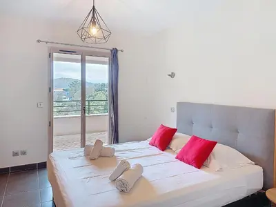 a bedroom with a large white bed with red pillows at Apartment Agnaredda by Interhome in Porto-Vecchio