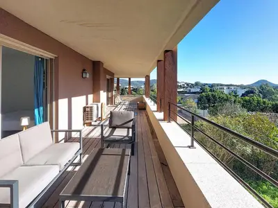 a balcony with a couch and chairs on it at Apartment Agnaredda by Interhome in Porto-Vecchio