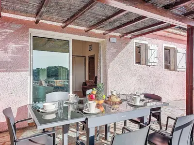 a table and chairs on a patio with a table at Apartment Marina Di Santa Giulia by Interhome in Porto-Vecchio