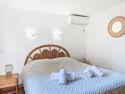a bedroom with a bed with blue sheets and a mirror at Apartment Marina Di Santa Giulia by Interhome in Porto-Vecchio
