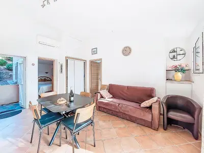 a living room with a couch and a table at Apartment Marina Di Santa Giulia by Interhome in Porto-Vecchio