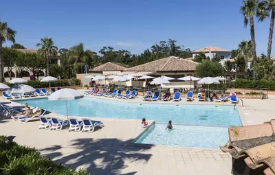 a pool at a resort with chairs and people in it at Apartment 4 people - next to the sea in Linguizzetta