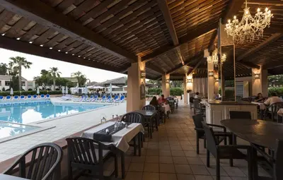 a restaurant with tables and chairs next to a swimming pool at Apartment 4 people - next to the sea in Linguizzetta