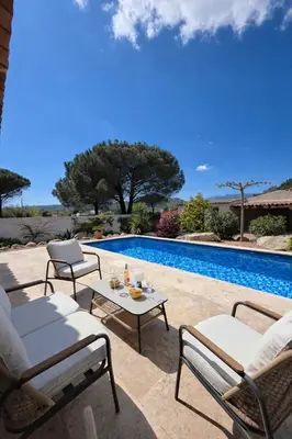 a living room with a white couch and a kitchen at Villa with pool near Porto-Vecchio beaches in Porto-Vecchio