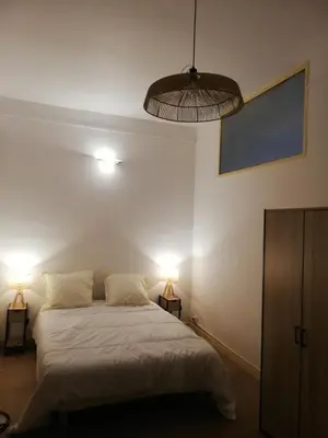 a bedroom with a bed with two lights on it at T2 hyper centre ville in Ajaccio