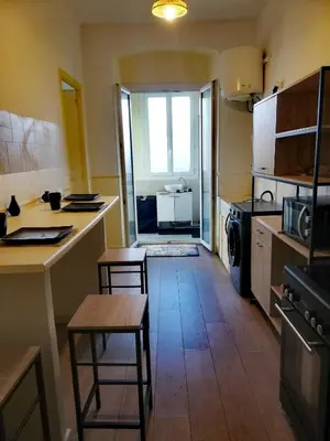 a kitchen with a table and chairs in a room at T2 hyper centre ville in Ajaccio