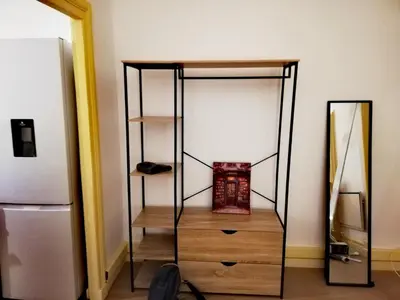 a closet with a wooden dresser and a refrigerator at T2 hyper centre ville in Ajaccio