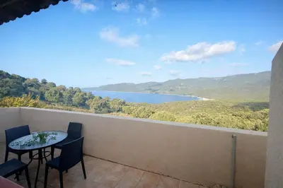 a balcony with a table and chairs and a view of a lake at Appartement 4 personnes - Soléa 229 - Vue Mer in Serra-di-Ferro