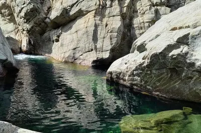 a pool of water in a canyon with rocks at Haut de Villa Superbe vue Piscine privee in Moltifao