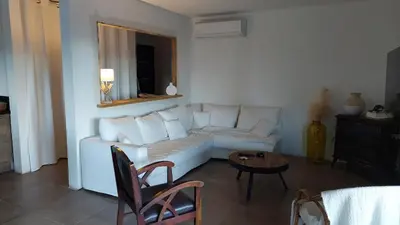 a living room with a white couch and a table at Haut de Villa Superbe vue Piscine privee in Moltifao