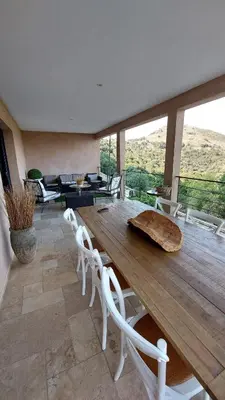 a dining room with a wooden table and chairs at Haut de Villa Superbe vue Piscine privee in Moltifao