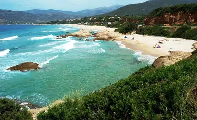 a beach with people on the sand and water at Residence I Delfini in Tiuccia