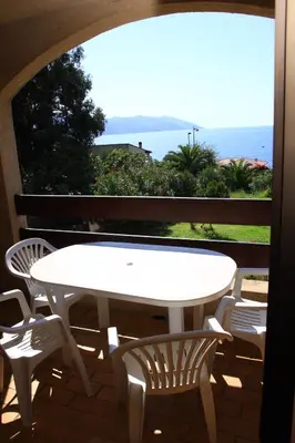 a table and chairs on a balcony with a view of the ocean at Residence I Delfini in Tiuccia