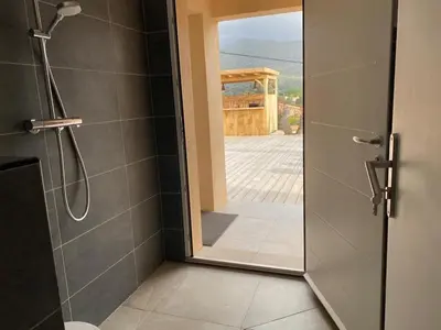a bathroom with a shower with a glass door at Cozy villa with pool in Eccica-Suarella