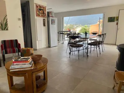 a living room with a table and chairs and a table at Cozy villa with pool in Eccica-Suarella