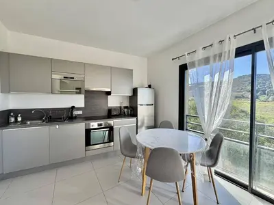 a kitchen with a table and chairs and a kitchen with a window at T2 à 200m des plages in Propriano