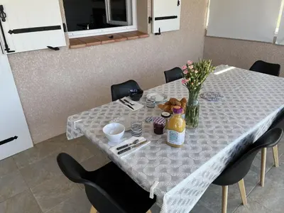 a table with chairs and a table with flowers on it at A Casa di Natalina in Piana