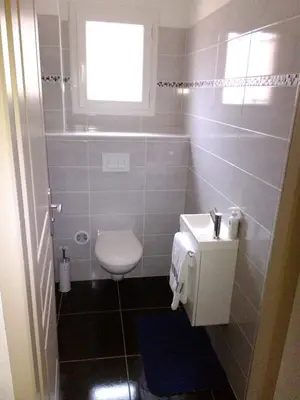 a bathroom with a toilet and a sink and a window at A Casa di Natalina in Piana