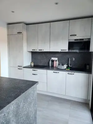 a kitchen with white cabinets and a black counter top at Corsu di Core - Villa Core di Favona in Conca