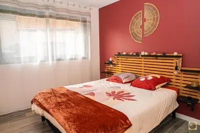 a bedroom with a large bed with red walls at Corsu di Core - Villa Core di Favona in Conca