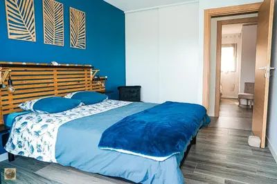 a blue bedroom with a large bed with blue pillows at Corsu di Core - Villa Core di Favona in Conca