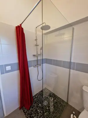 a shower with a red shower curtain in a bathroom at Villa pour4 pers à 700m de la plage de palombaggia in Porto-Vecchio