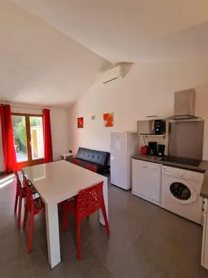 a living room with a white table and red chairs at Villa pour4 pers à 700m de la plage de palombaggia in Porto-Vecchio