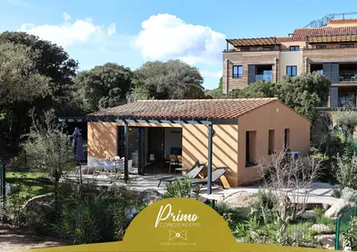 a tiny house in a garden in front of a building at A Marinca - Plage privée et piscine chauffée in Pianottoli-Caldarello