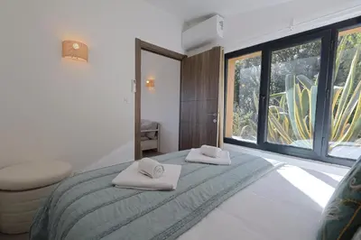 a bedroom with two towels on a bed with a window at A Marinca - Plage privée et piscine chauffée in Pianottoli-Caldarello