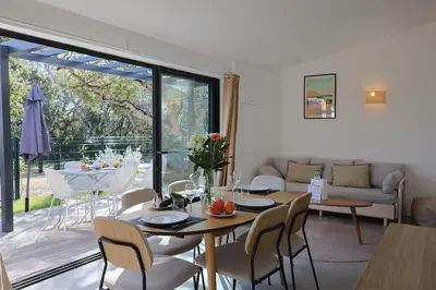 a living room with a table and chairs and a large window at A Marinca - Plage privée et piscine chauffée in Pianottoli-Caldarello