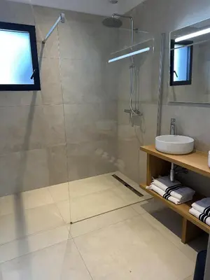 a bathroom with a glass shower and a sink at Villas Vangarone in Lecci