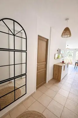 a living room with a door and a table at Appartement 40 m2 Piscine vue panoramique sur Cupabia in Serra-di-Ferro
