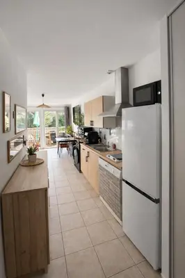 a kitchen with a white refrigerator and a table at Appartement 40 m2 Piscine vue panoramique sur Cupabia in Serra-di-Ferro