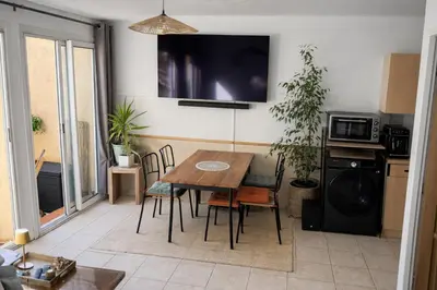 a kitchen with a table and chairs and a television at Appartement 40 m2 Piscine vue panoramique sur Cupabia in Serra-di-Ferro
